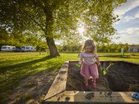 Meisje in zandbak op de camping